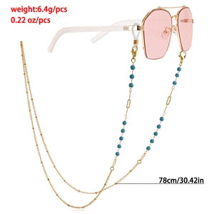 Chaîne de lunettes dorée avec perles bleu-vert et longueur de 78 cm sur lunettes