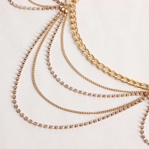 Détail de bijoux de corps dorés multicouches avec franges en strass de cristal étincelants