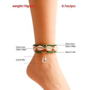 Detailed view of bohemian anklet set with green beads, sea shell, and evil eye charm