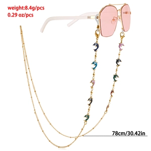 Détail d'une chaîne à lunettes dorée de 78cm avec pendentifs dauphins colorés en émail