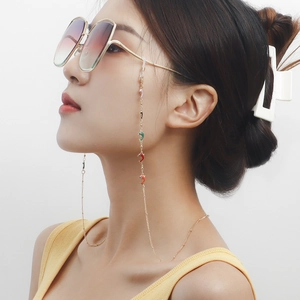 Détail de la chaîne à lunettes dorée avec pendentifs dauphins colorés et boucles en silicone