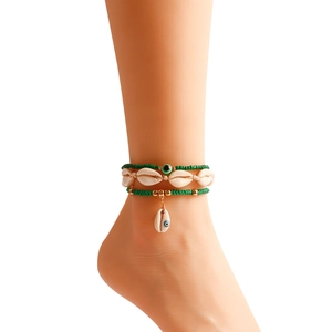 Close-up of Bohemian anklet set with natural shells, evil eye beads and woven rope