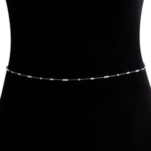 Détail d'une élégante chaîne de taille argentée avec mini perles sur mannequin noir