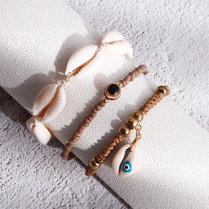 Close-up of Bohemian handmade anklet set with shells, evil eye beads and braided cords