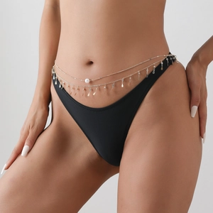 Détail de la chaîne de taille dorée multicouche avec perles et strass brillants au soleil