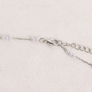 Détail de la chaîne de corps argentée avec mini perles et fermoir mousqueton réglable