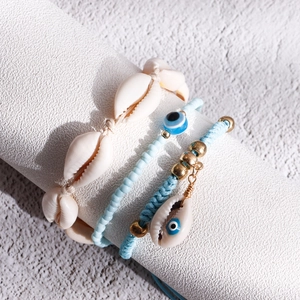 Detailed view of bohemian beach anklet set featuring natural shells and blue beads