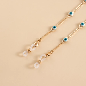 Macro shot of gold rectangular link chain with colorful evil eye beads and silicone loops