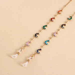 Détail de la chaîne de lunettes dorée avec pendentifs dauphins colorés et fermoirs mousquetons