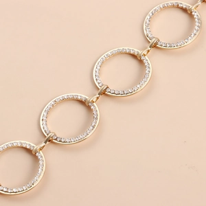 Dettaglio della catena da vita dorata con cerchi decorati con micro-pavé di zirconi