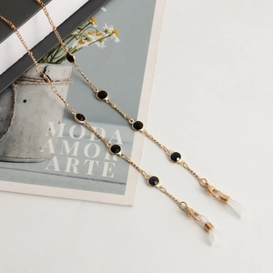 Chaîne de lunettes dorée élégante avec perles noires et fermoirs mousquetons sur fond blanc