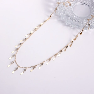 Détails d'une chaîne de taille dorée avec des paillettes goutte d'eau et strass scintillants