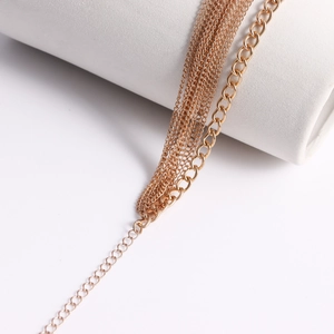 Macro view of multi-layer rose gold body chain focusing on refined O-chains and links