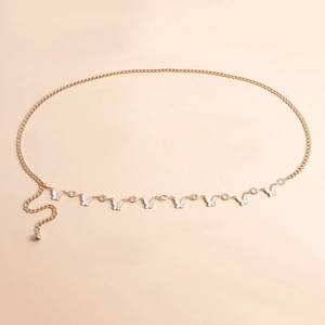 Detail of gold metal waist chain featuring white enamel butterfly and rhinestone charms