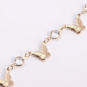 Detailed close-up of golden butterfly waist chain with sparkling round crystal stones