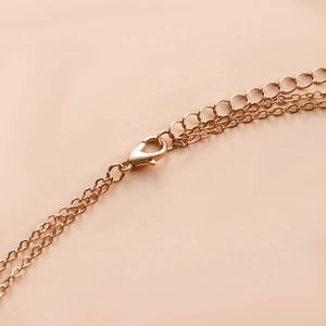 Detail of layered gold jewelry chain featuring a secure lobster clasp and adjustable links