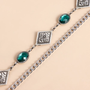 Dettaglio della catena per il corpo con pietre verde smeraldo e maglie in metallo floreali