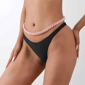 Dettaglio di una catena in vita a doppia fila di perle finte rosa su una modella