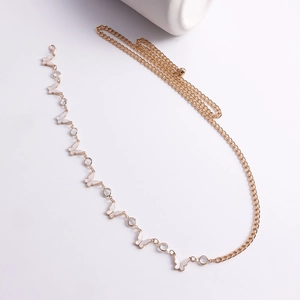 Detail of gold waist chain featuring white butterfly motifs and sparkling rhinestones