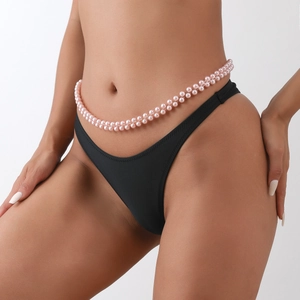 Dettaglio di una catena in vita a doppia fila di perle rosa per un look sexy da spiaggia