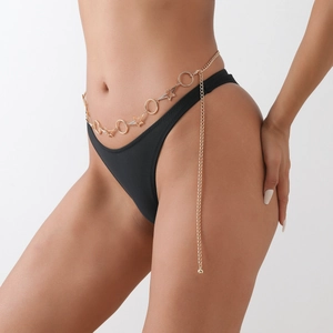 Detailed view of a gold starfish and hoop link body chain with long tassel on a female waist