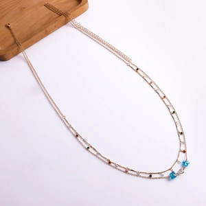 Close-up of golden double-layer body chain with colorful charms and lobster clasp closure