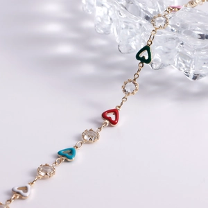 Detail of gold chain with multi-color enamel hearts and sparkling crystal charms