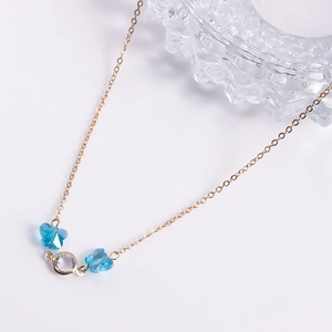 Close-up of gold chain belt featuring blue butterfly crystals and clear round pendants