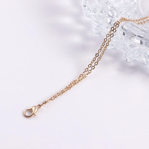 Close-up of golden dual-layer body chain with lobster clasp and drip oil droplet charms