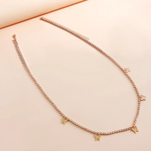 Dettaglio della catena da vita in oro rosa con farfalle e strass lucidi per look sexy