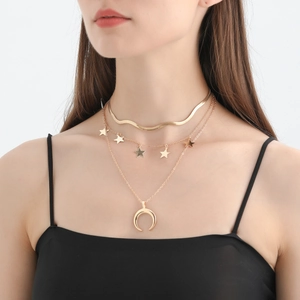 Collana dorata a tre strati con ciondoli a stella e pendente a mezzaluna su modella