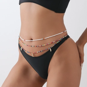 Close-up of three-layer bohemian waist beads with gold shell charms on model's skin