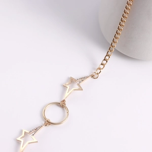 Detailed close-up of golden starfish waist chain with sparkling rhinestones on white base