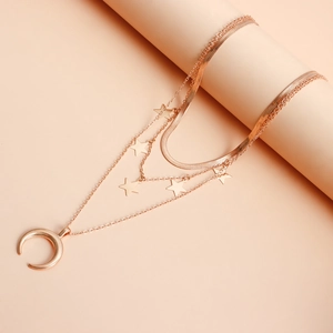 Dettaglio della collana a tre strati in oro rosa con ciondoli a stella e mezzaluna