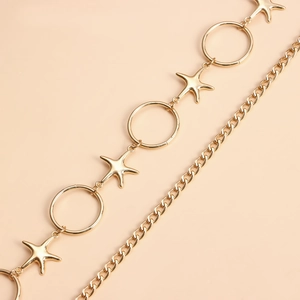 Detailed macro view of the gold starfish and circular ring elements on a metal body chain