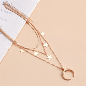 Dettaglio della collana a tre strati con catena a serpente, stelle e ciondolo a luna