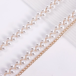 Dettaglio della catena in vita con perle intrecciate e oro per un bikini sexy