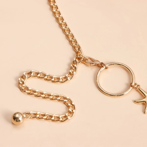 Detail of gold starfish body chain with circle links and smooth metallic texture