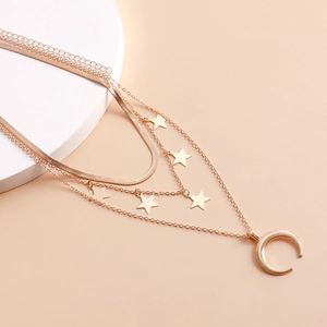 Dettaglio della collana girocollo dorata a più strati con paillettes a stella e ciondolo luna