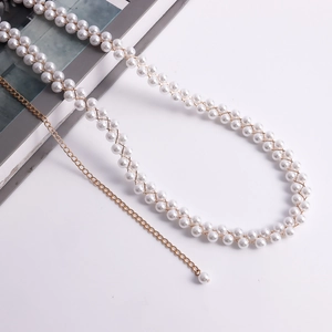 Dettaglio di una catena da vita con perle ed eleganti maglie metalliche dorate