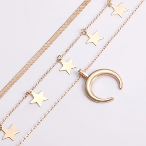 Dettaglio della collana a tre strati dorata con stelle e pendente a forma di luna