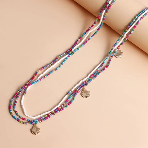 Detail of colorful beads and gold seashell pendants on a boho beach waist chain set