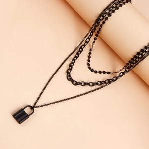 Detail view of multi-layer black padlock necklace featuring matte chain links and a lock charm