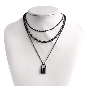 Detailed view of triple-layered black chain necklace featuring a minimalist padlock pendant