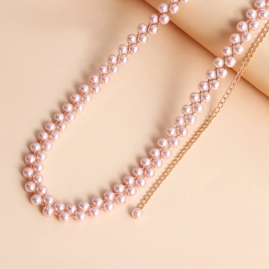 Dettaglio catena corpo in perle rosa con trama a rete dorata ed estensione regolabile