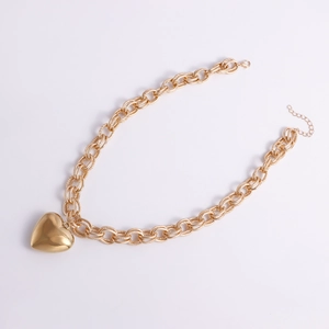 Close-up of gold chain necklace featuring a large polished heart pendant with lobster clasp
