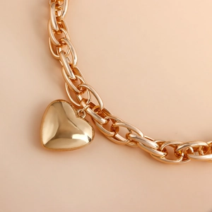 Close-up of thick gold-tone chain link necklace with large hollow heart pendant
