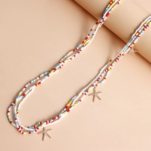 Detailed view of colorful multi-layer beaded necklace with golden starfish charms for summer