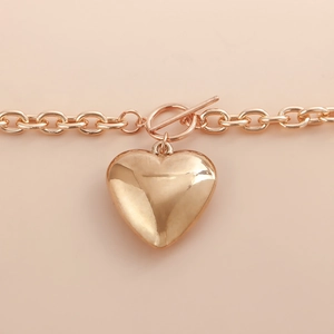 Macro shot of rose gold alloy chain with a large heart pendant and OT toggle clasp closure