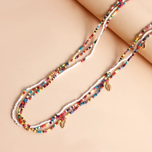 Detail of colorful beads and golden shell pendants on a beach body chain jewelry set